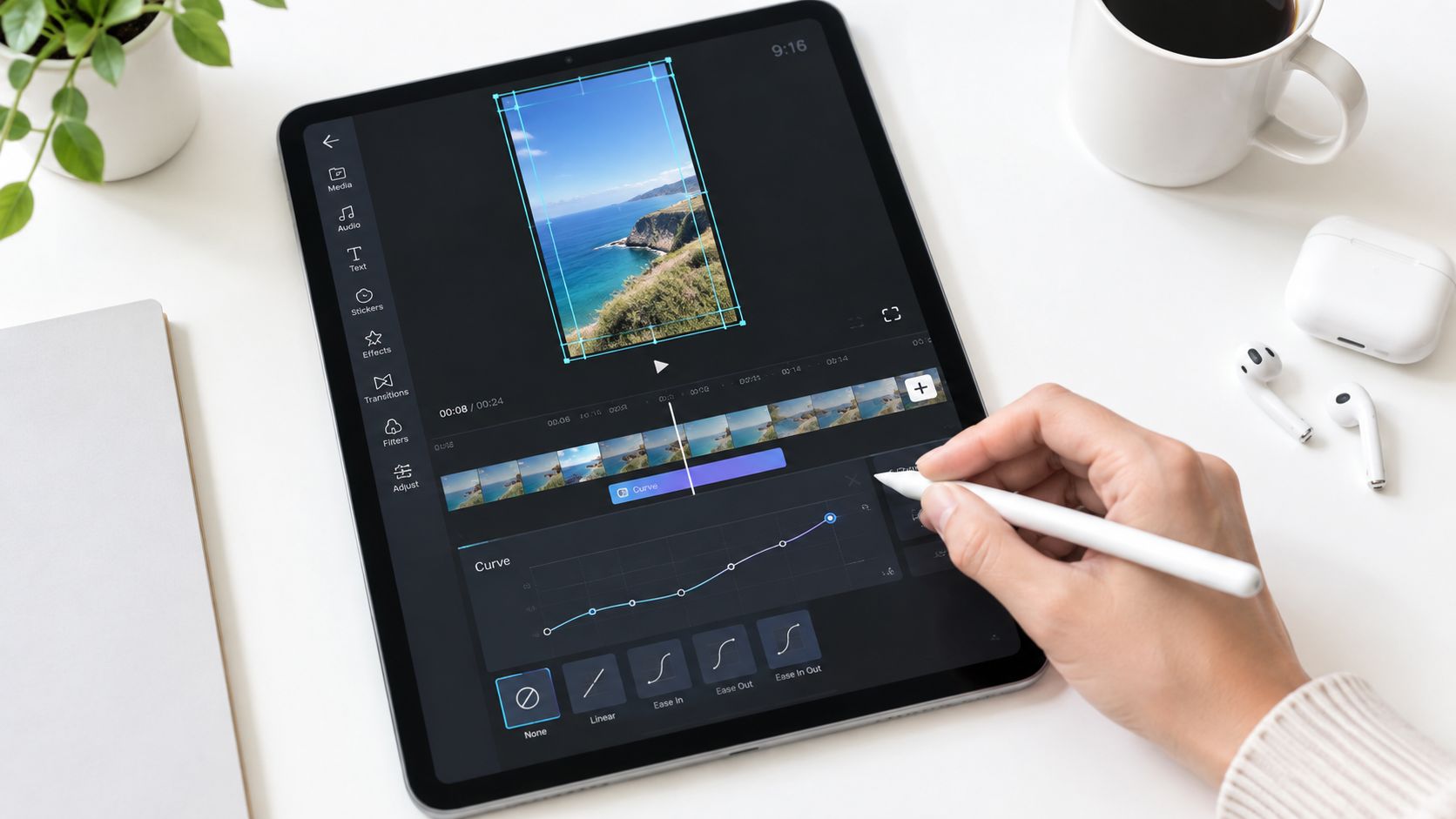 A person using a stylus on a tablet to edit a video of coastal scenery.